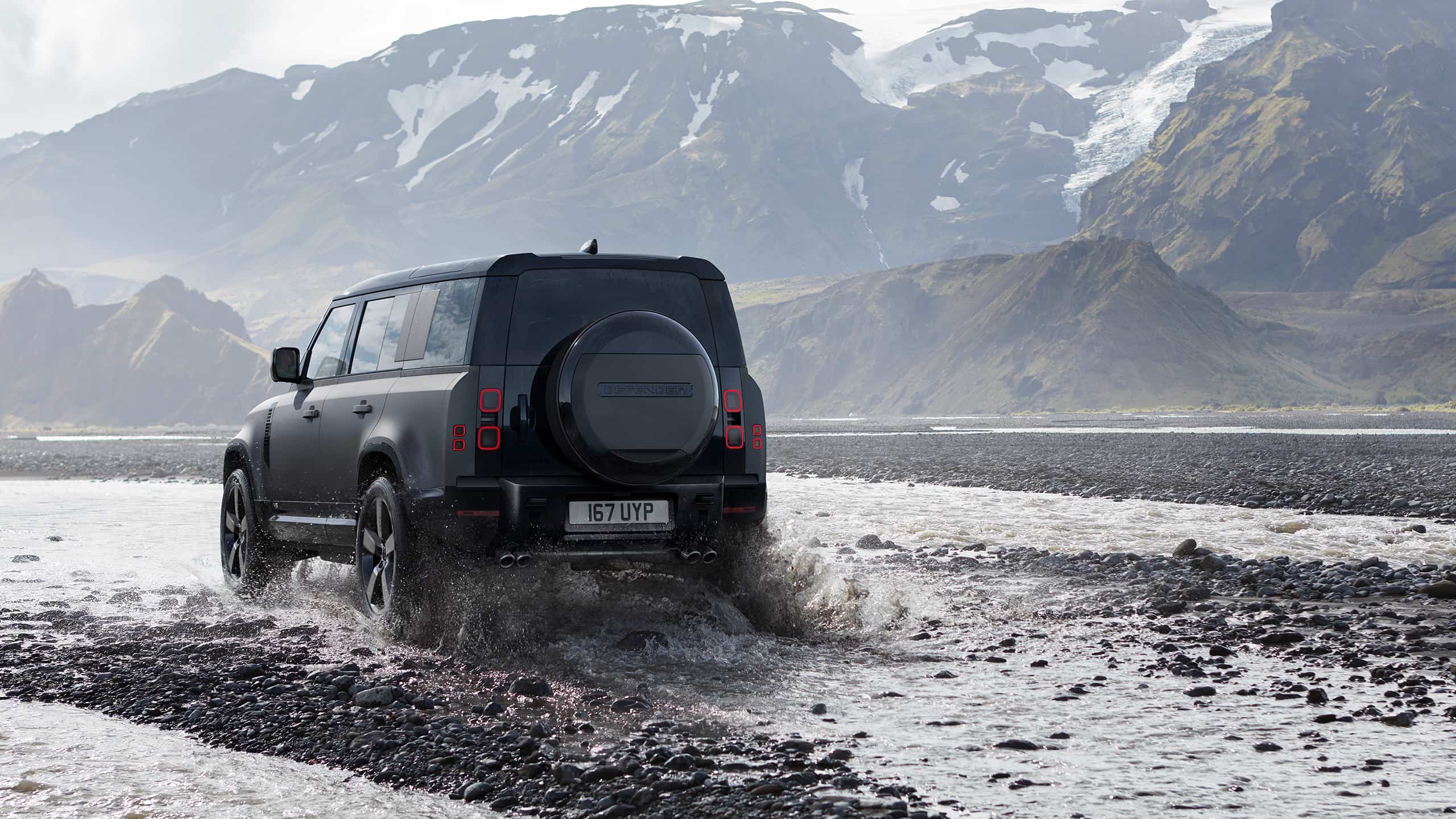 Defender is off roading in the mud of the river