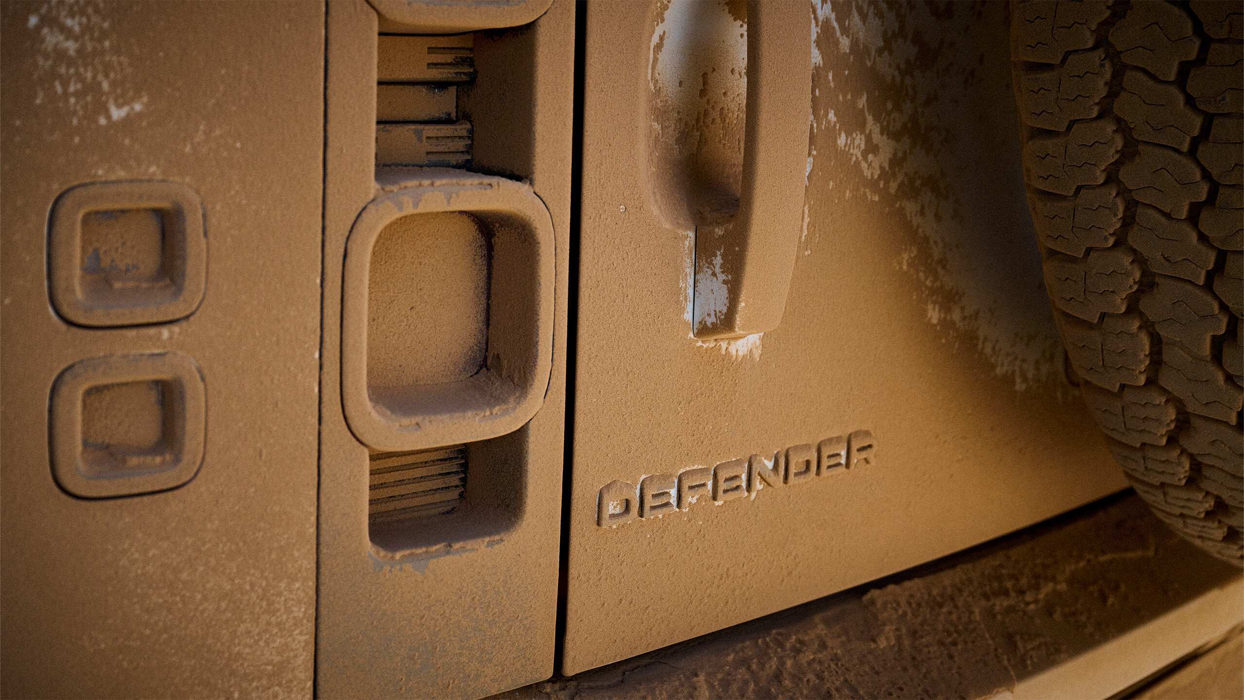 Defender embossed logo covered in dirt